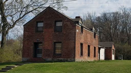 A brick house with a garage and a garage

AI-generated content may be incorrect.